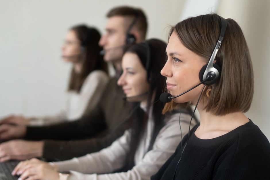 Support team wearing headsets working at their desks