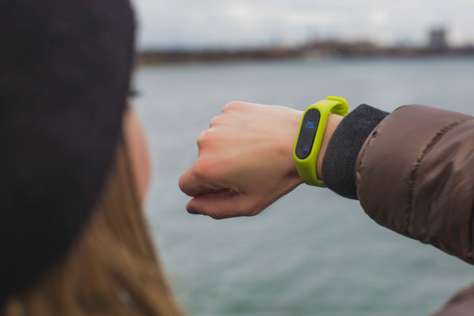 Person checking a connected wearable device outdoors